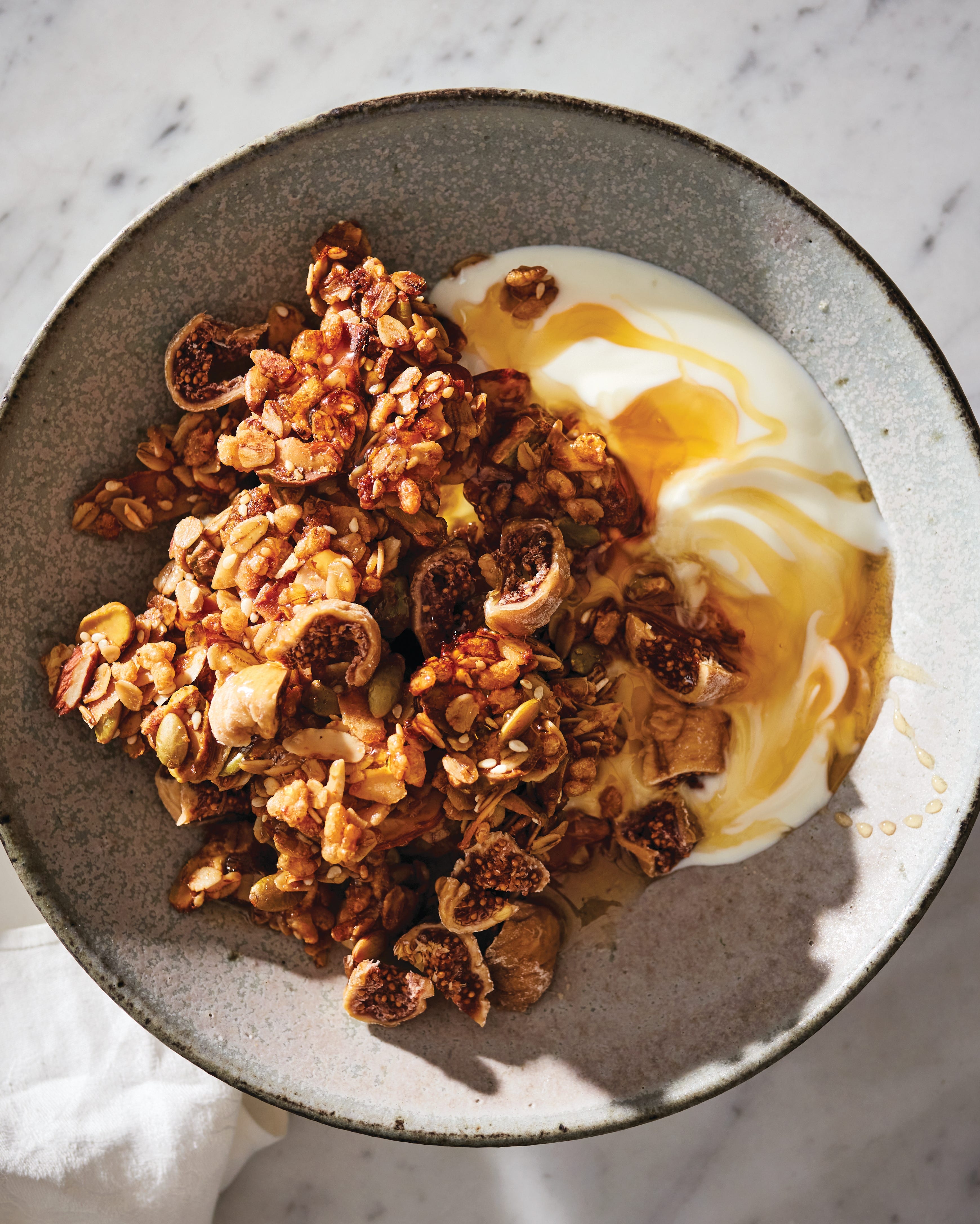A breakfast bowl with oats, fruit and seeds on a bright table